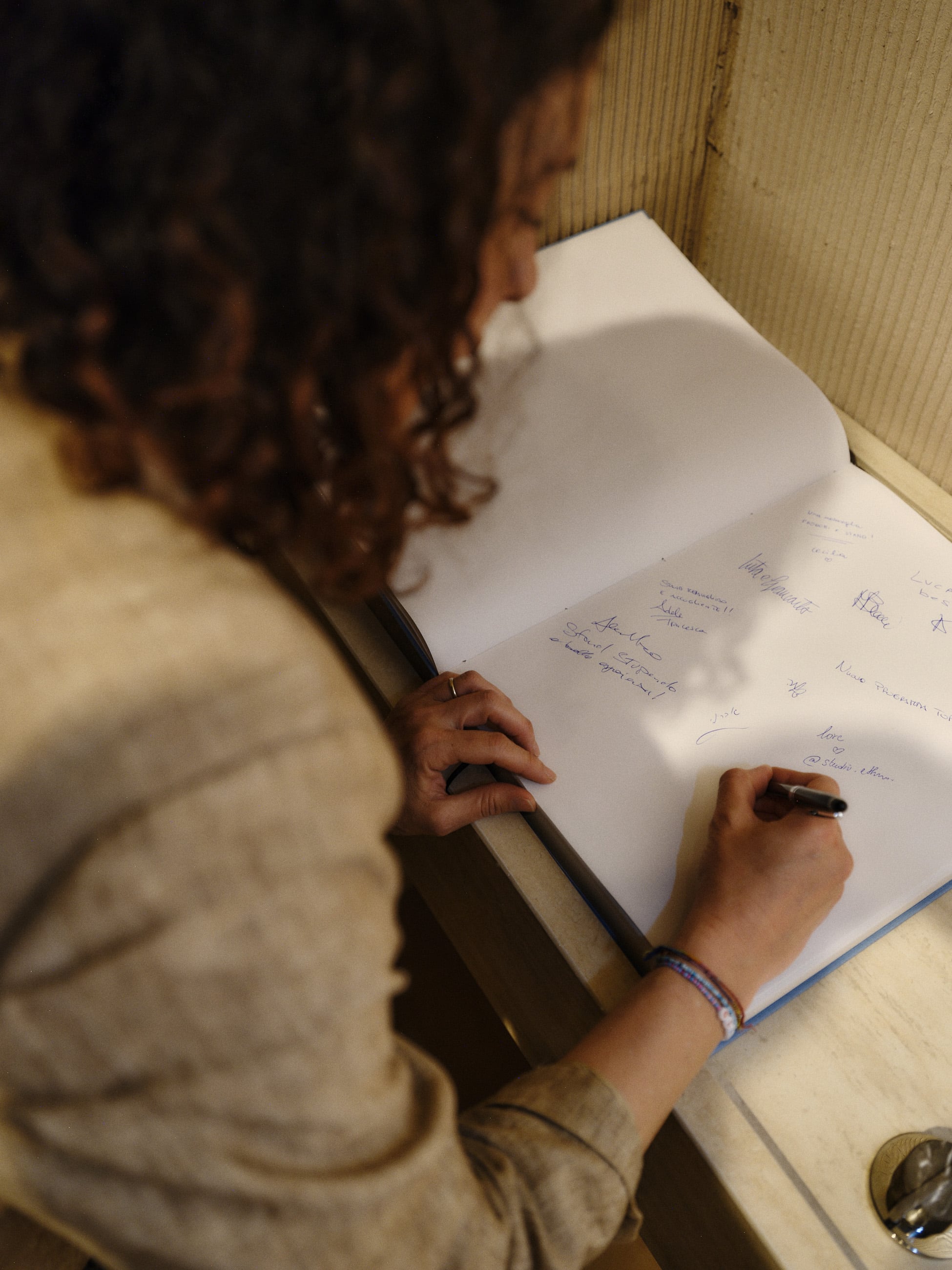 A woman signing a large guestbook