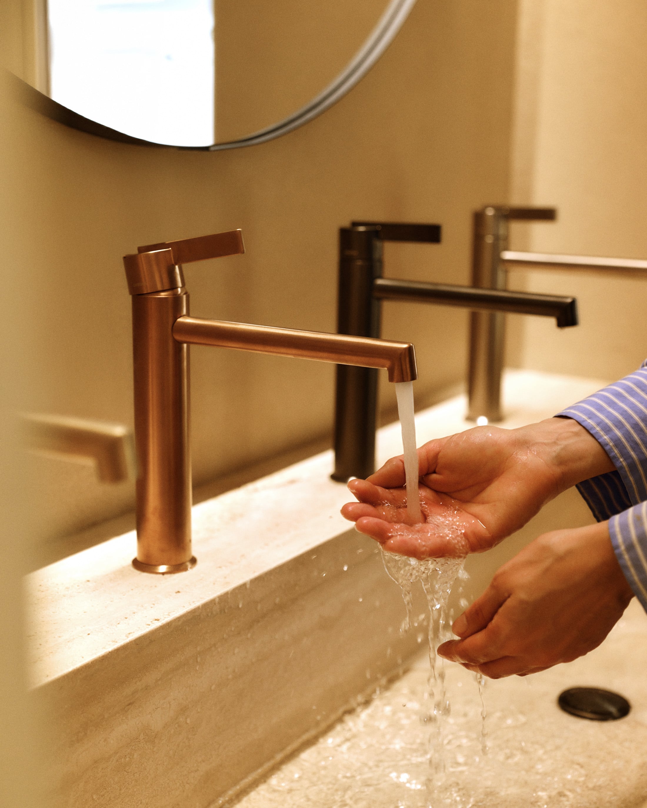 Hands being washed using a brass tap