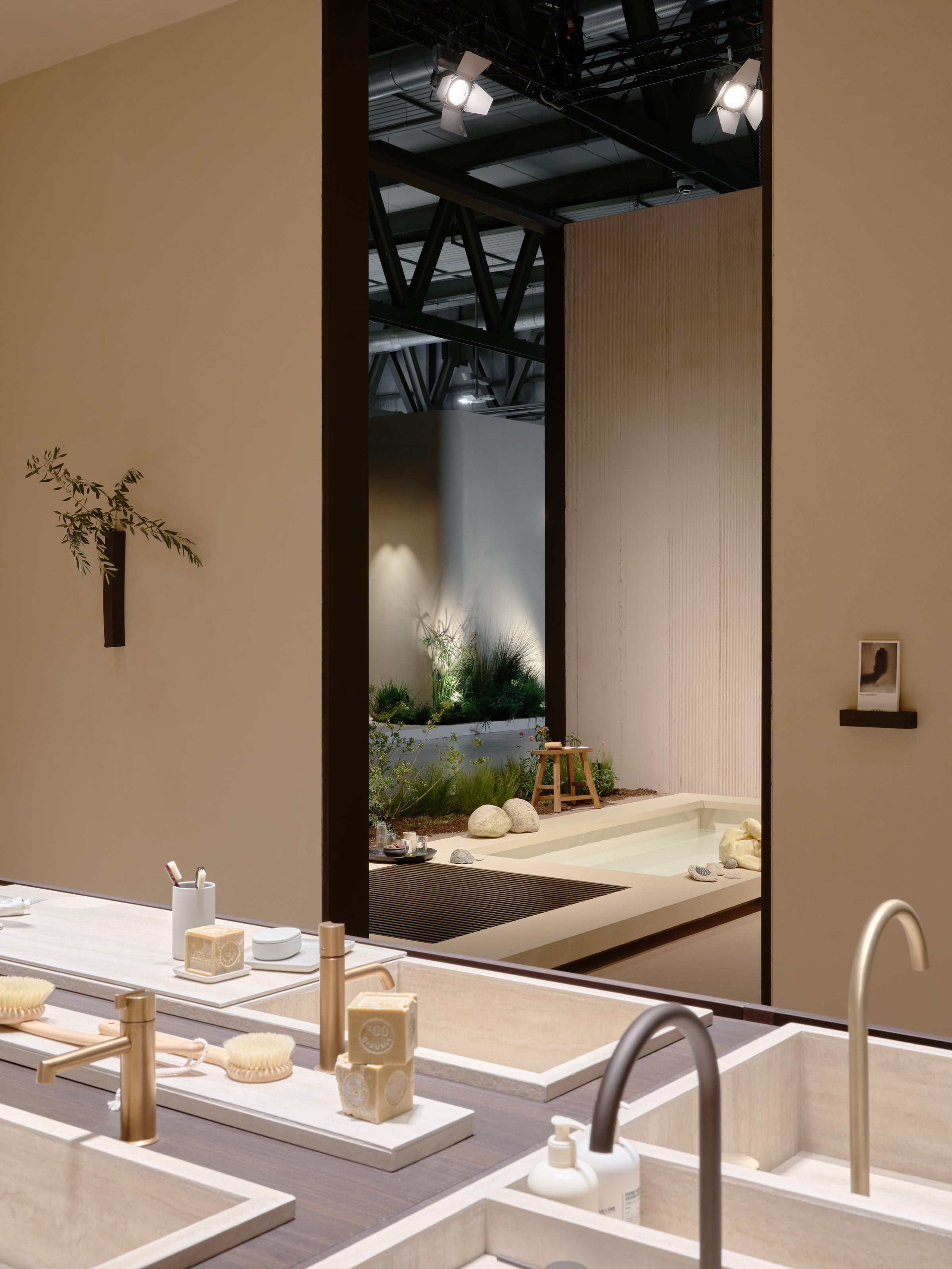 A view of a large bathroom installation with a number of taps installed in front of a space styled to look like an outdoor patio at the CRISTINA Salone del Mobile fair stand